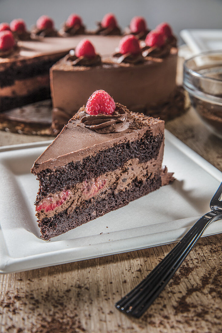 Slice of chocolate raspberry mousse cake on square white plate