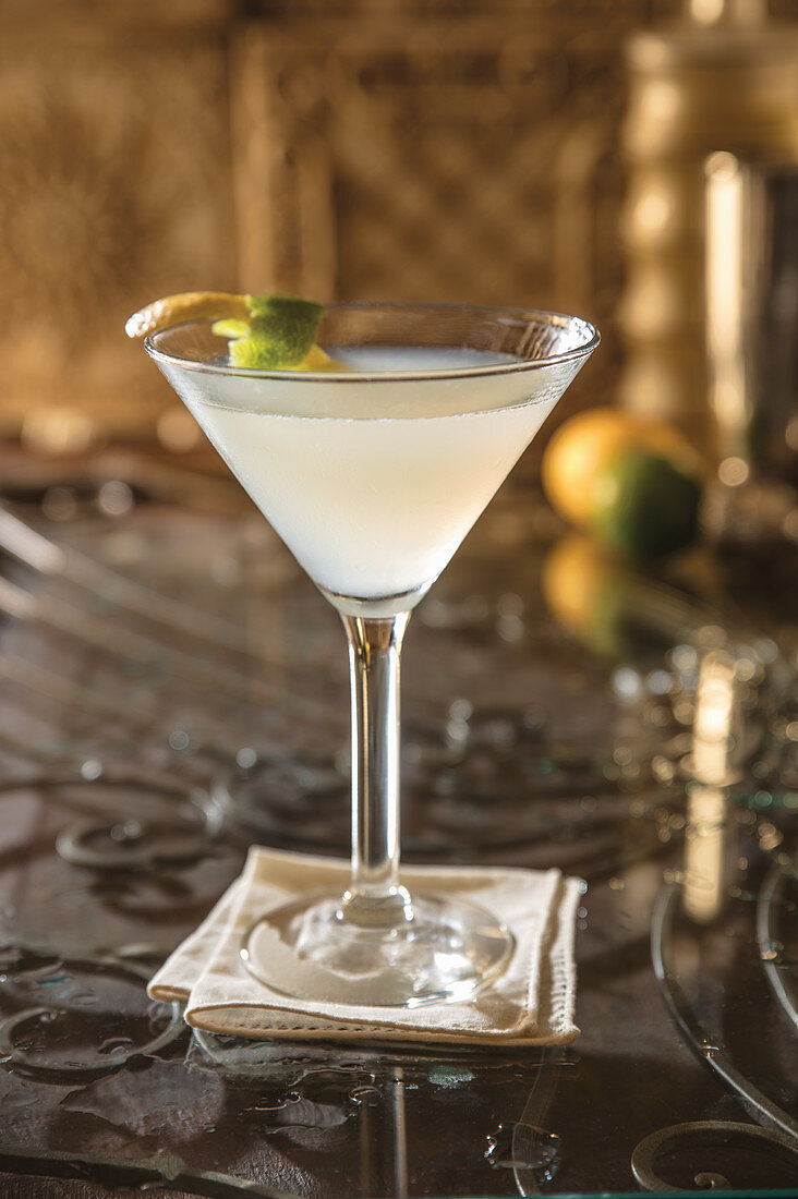 Fizz-Cocktail im Martiniglas mit Zitronen- und Limettenschale