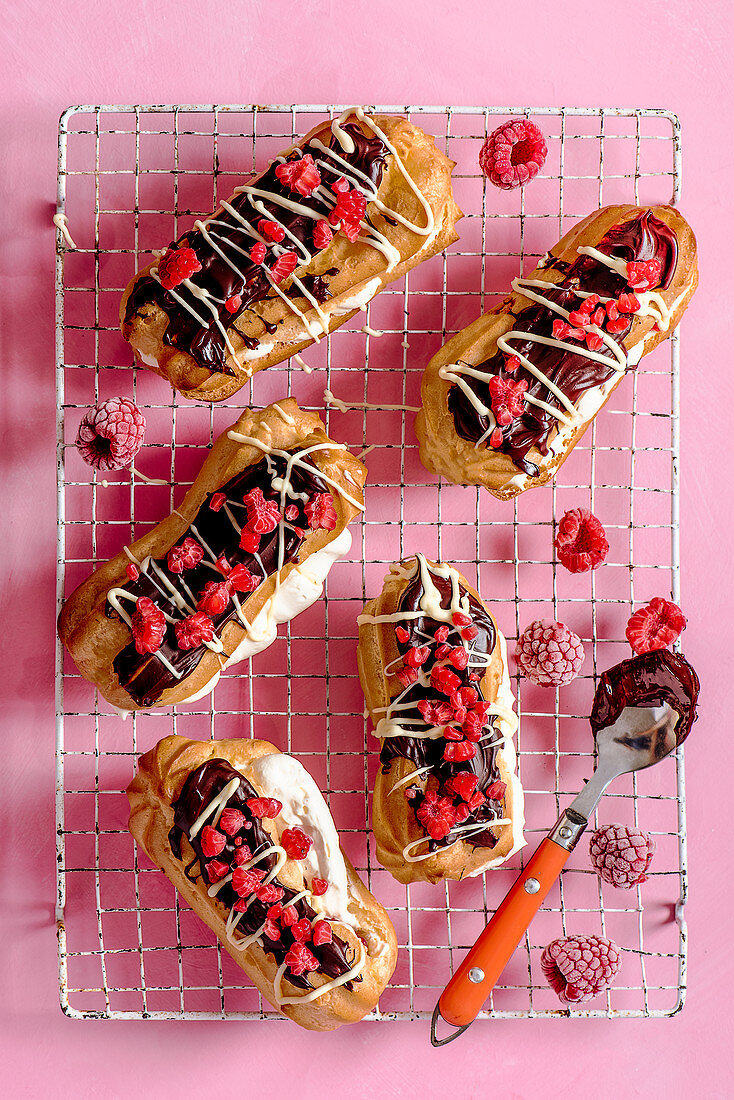 Selbstgemachte Eclairs mit Schlagsahne, Himbeeren und Schokolade