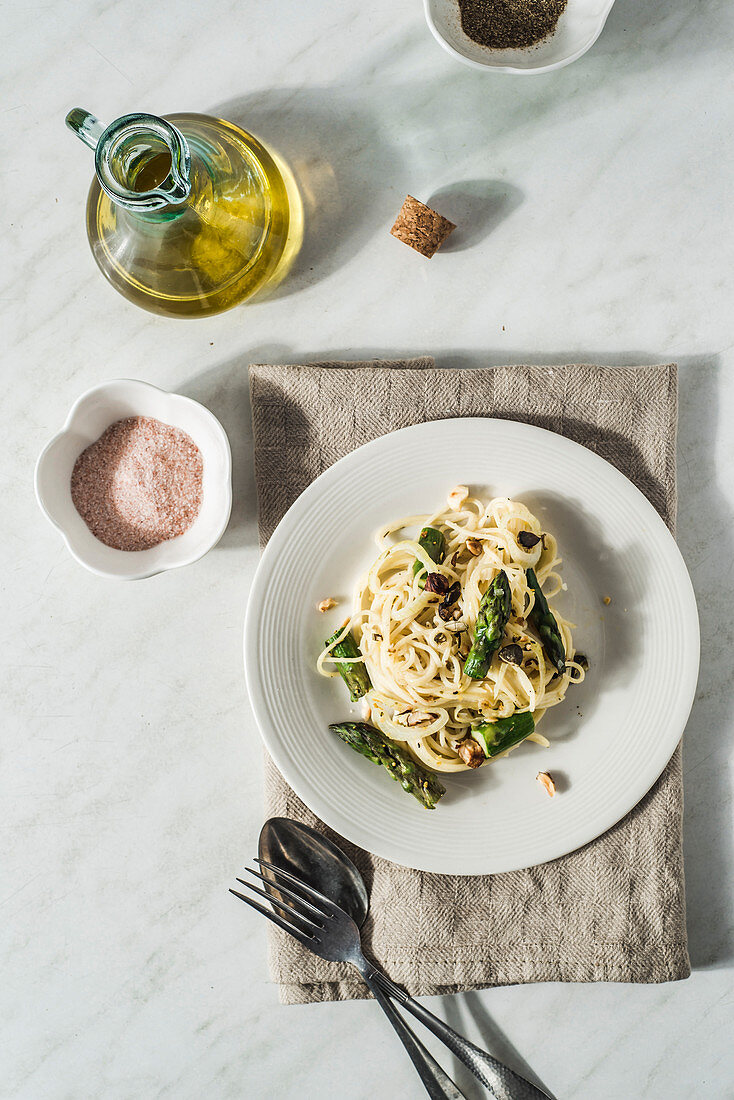 Spaghetti with asparagus, cream cheese and lemon sauce, , pumpkin seeds, onion and olive oil