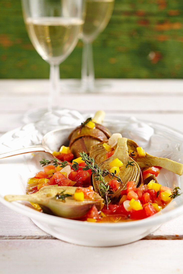 Young pickled artichokes with tomatoes, peppers, vinegar, oil, lemon, white wine and spices