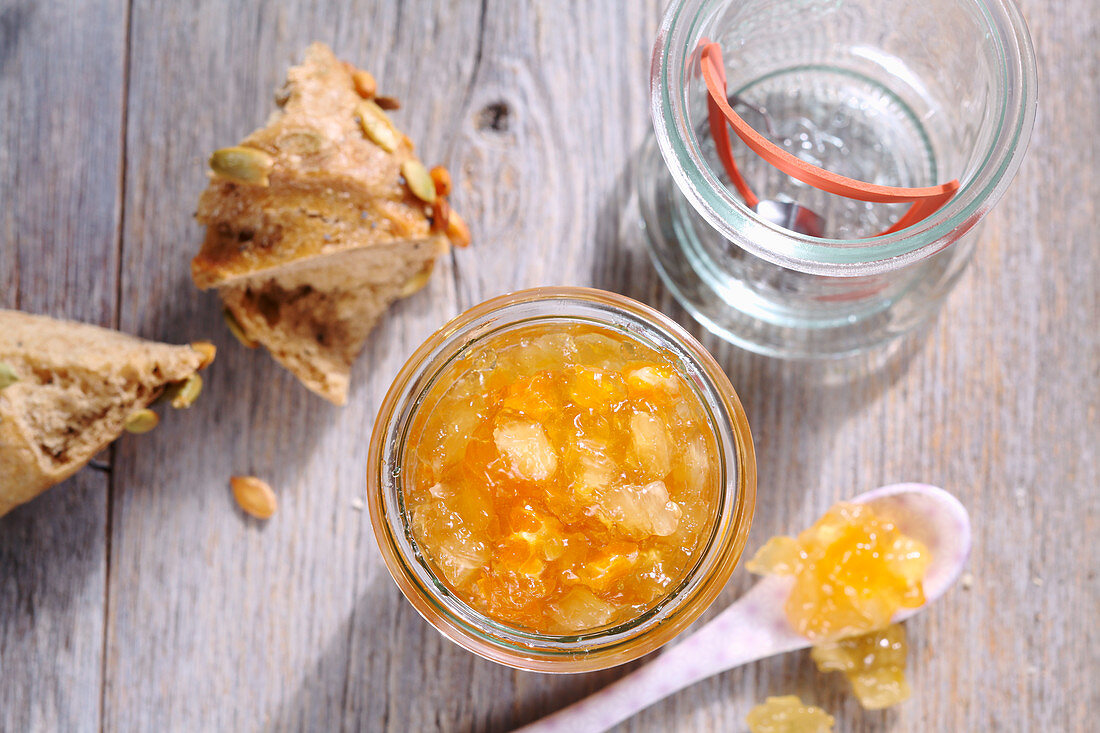 A jar of pineapple and orange conserve served with bread
