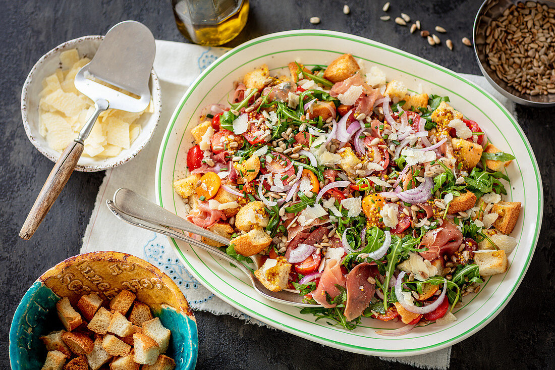 Kirschtomatensalat mit Rucola, Serranoschinken, Croûtons und Parmesan