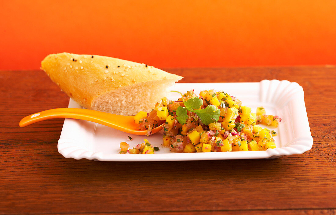 Pineapple and mango salsa with onion, coriander and lime on a paper plate