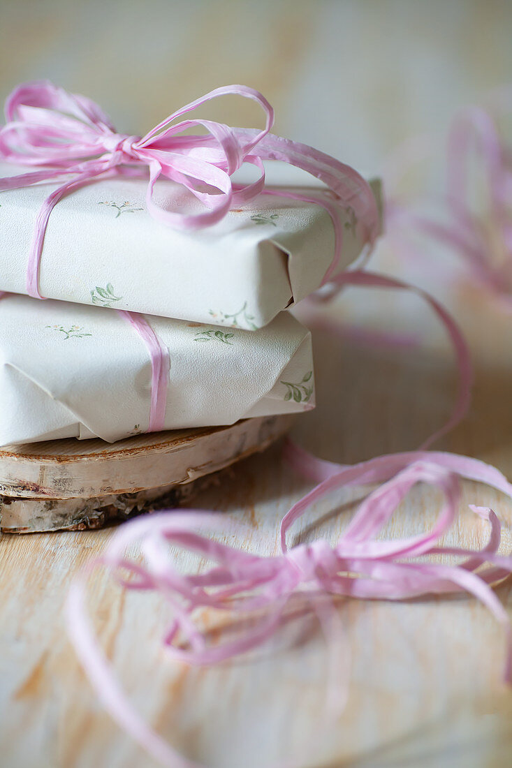 Gifts wrapped in white paper and pink ribbon