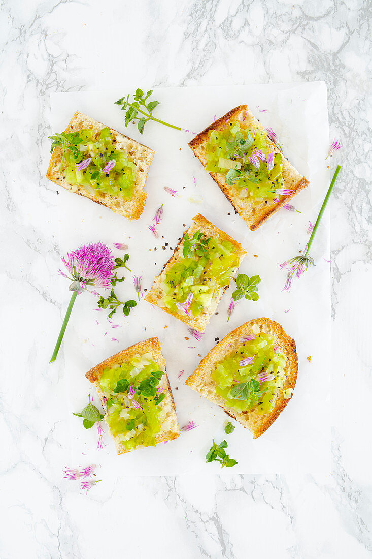 Crostini with green tomatoes, oregano and chive flowers