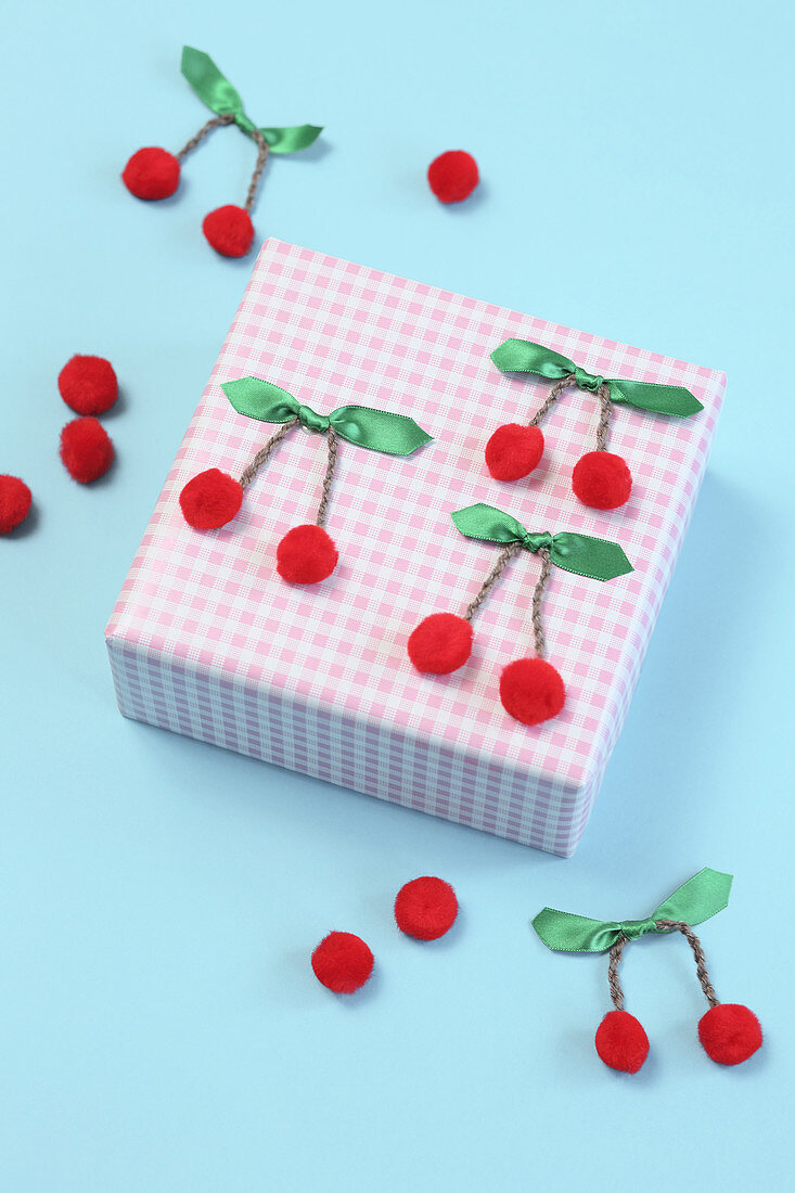 Hand-crafted cherries decorating wrapped gift
