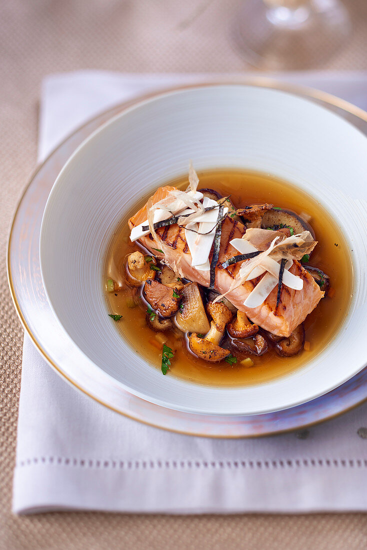 Broth with mushrooms and a salmon fillet