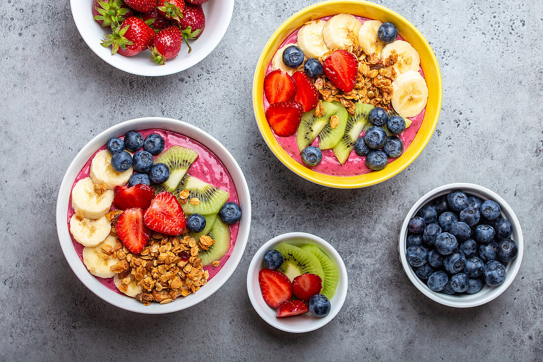 Summer acai smoothie bowls with strawberries, banana, blueberries, kiwi fruit and granola