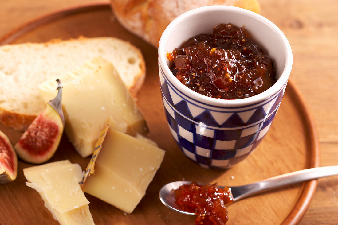 Homemade fig chutney served with cheese on a wooden board