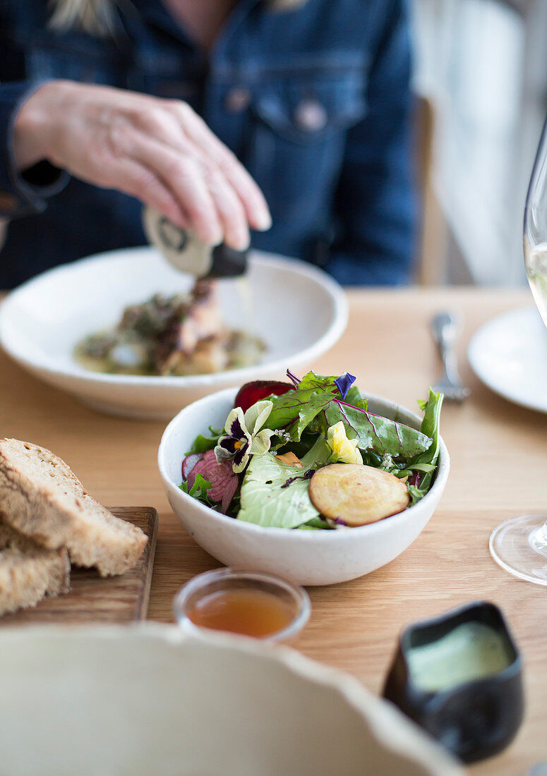 Bunter Salat mit Essblüten auf Tisch