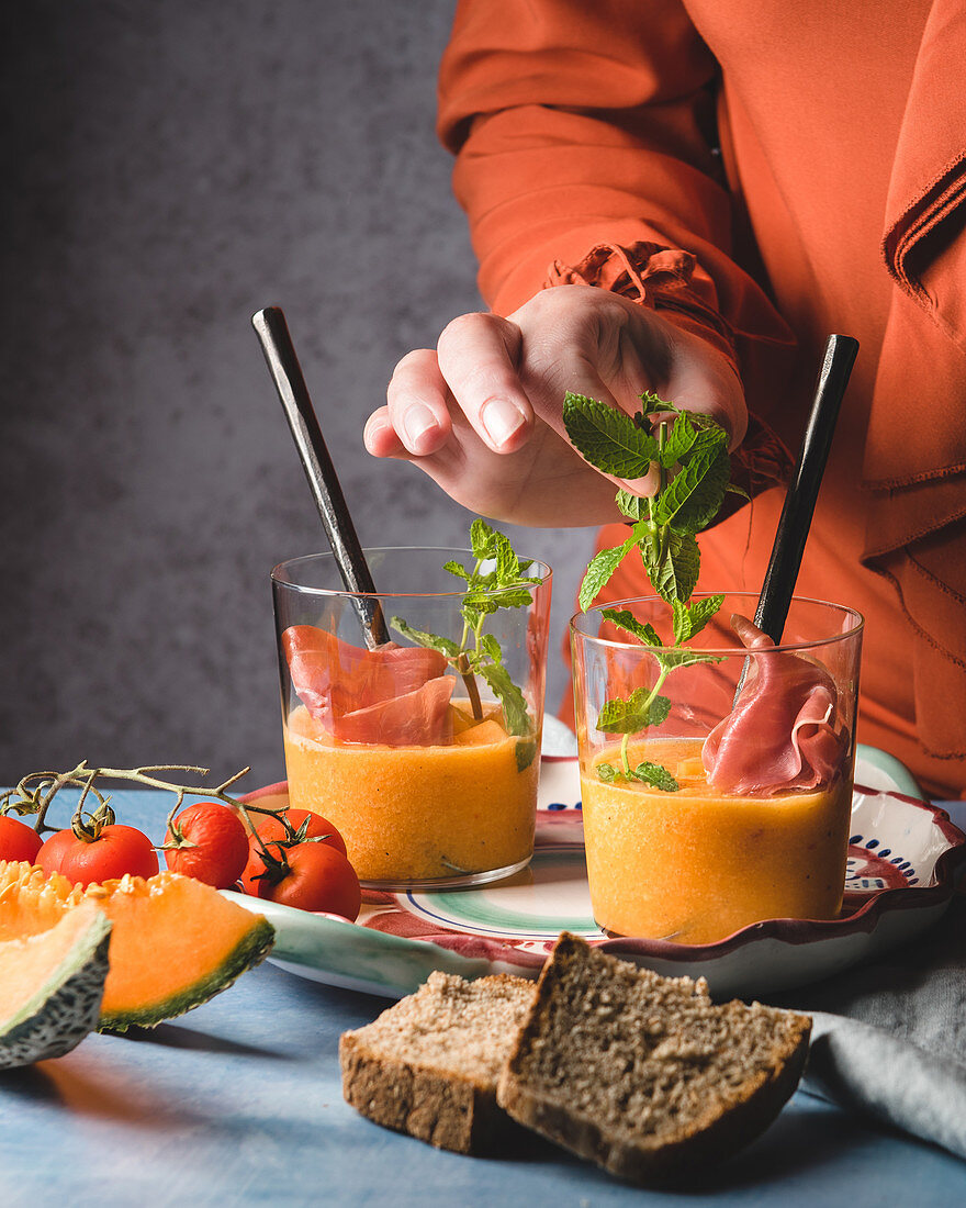 Melonen-Gazpacho mit Schinken und Minze anrichten