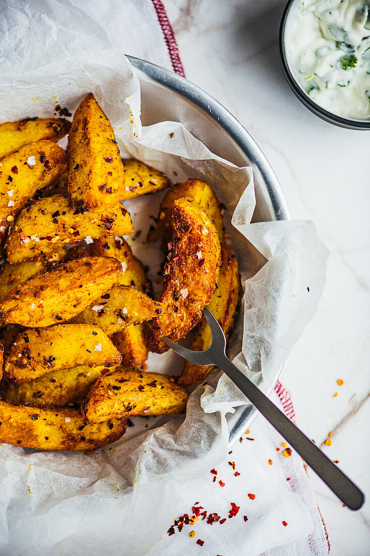 Spicy potato wedges from a pressure cooker served with a dip