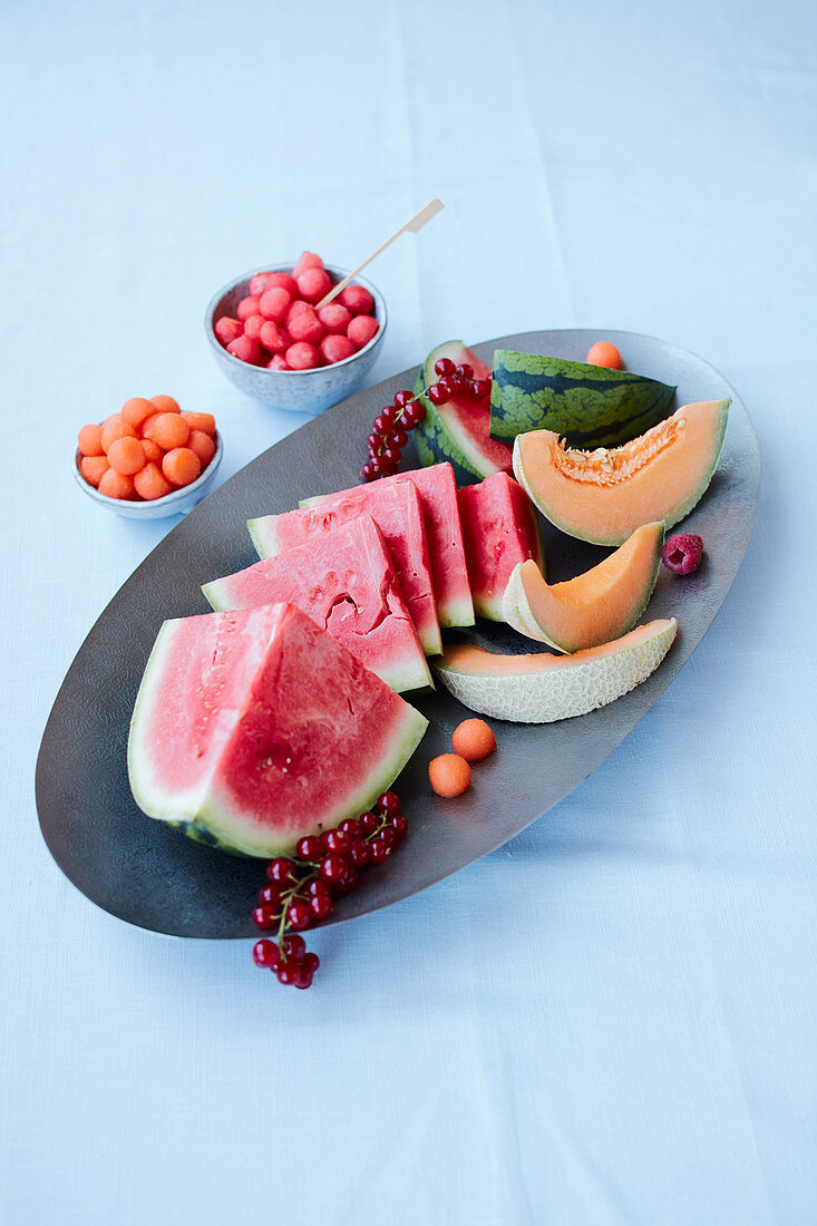 An arrangement of melon with watermelon, cantaloup melon, melon balls and redcurrants