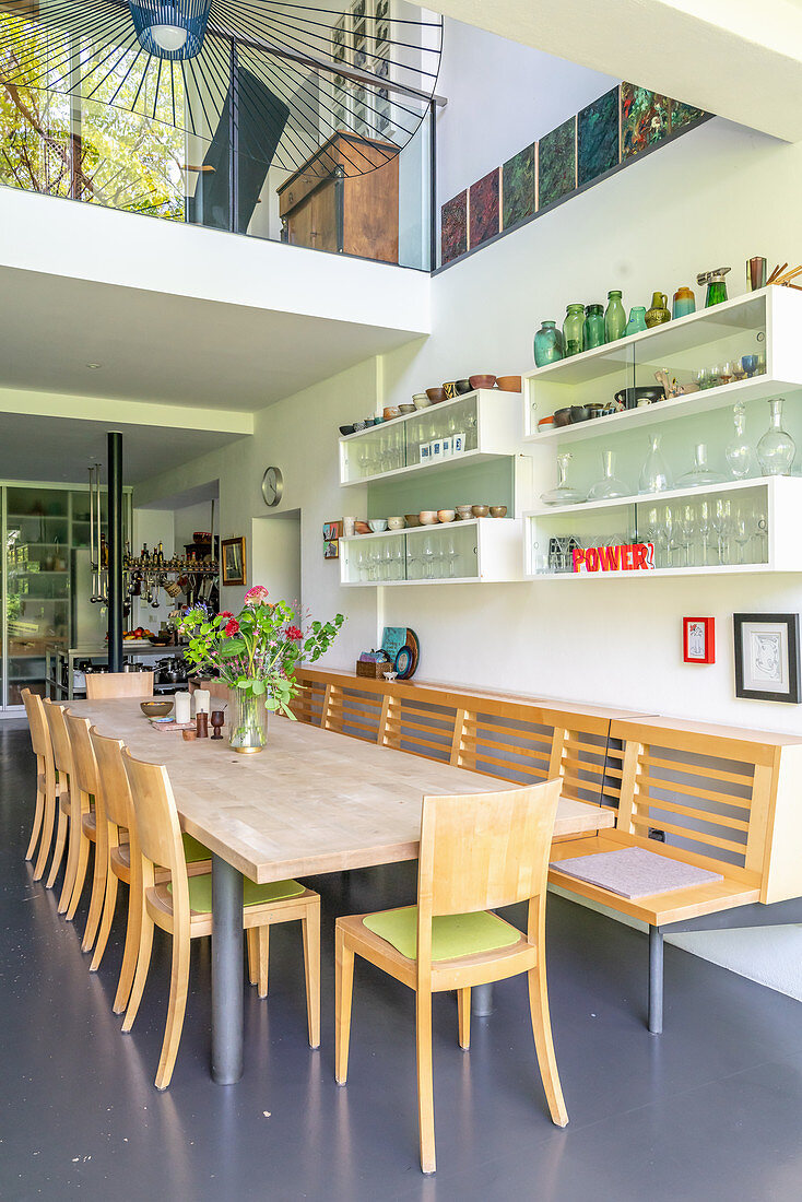 Dining area in high-ceilinged room with gallery