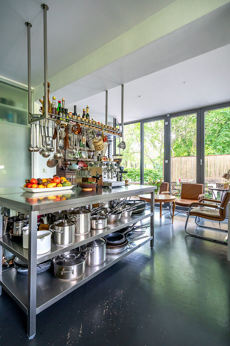 Island counter with stainless steel shelves below in open-plan interior