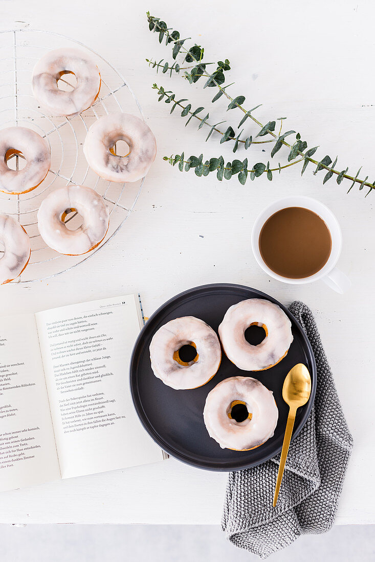 Marmor-Donuts mit weißer Zuckerglasur zum Kaffee