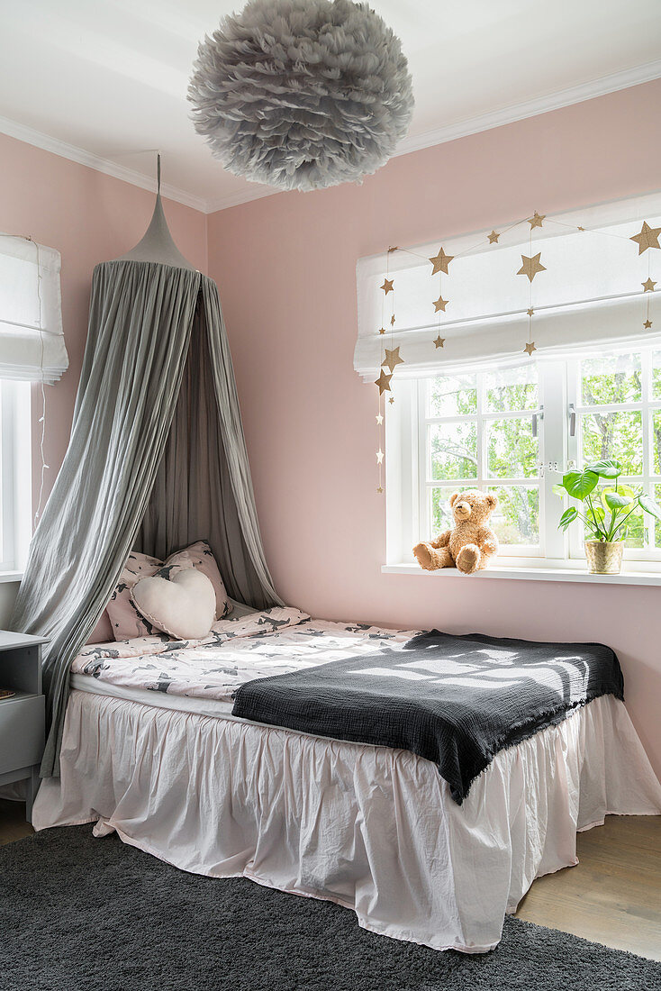 Bed with valance and canopy in girl's bedroom in pink and grey