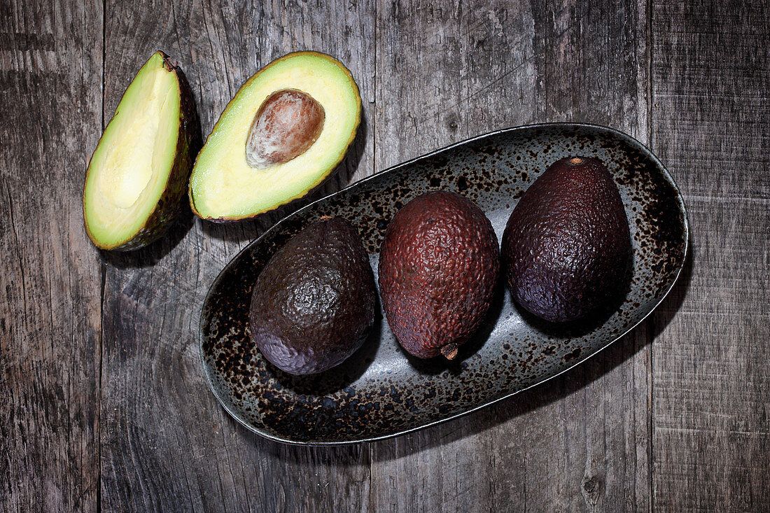 Avocados in and beside a ceramic bowl