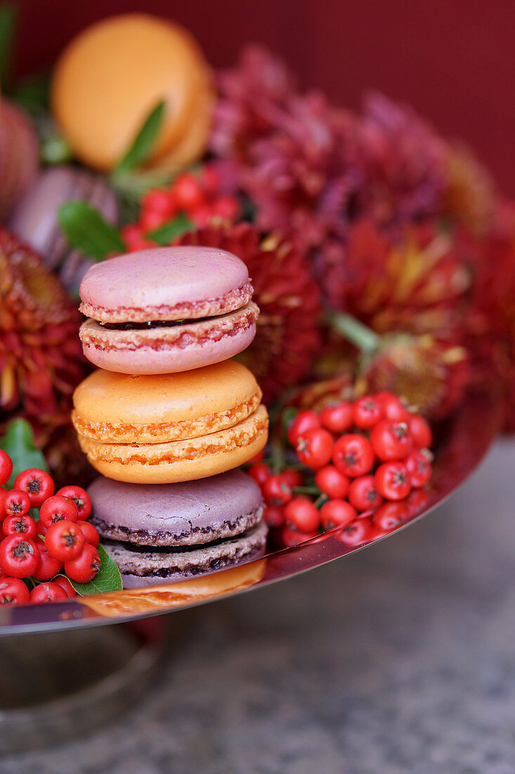 Passion fruit, cassis and blackberry macarons on a pastry platter (close-up)