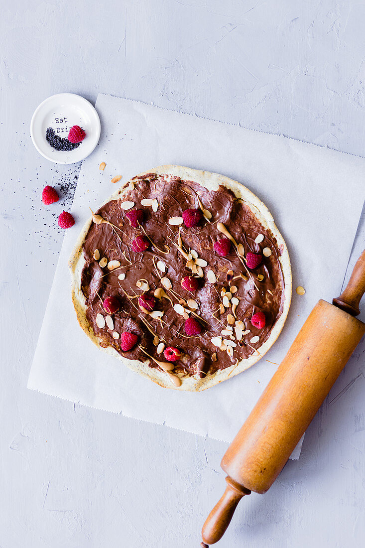 Chocolate pizza with raspberries and almond flakes