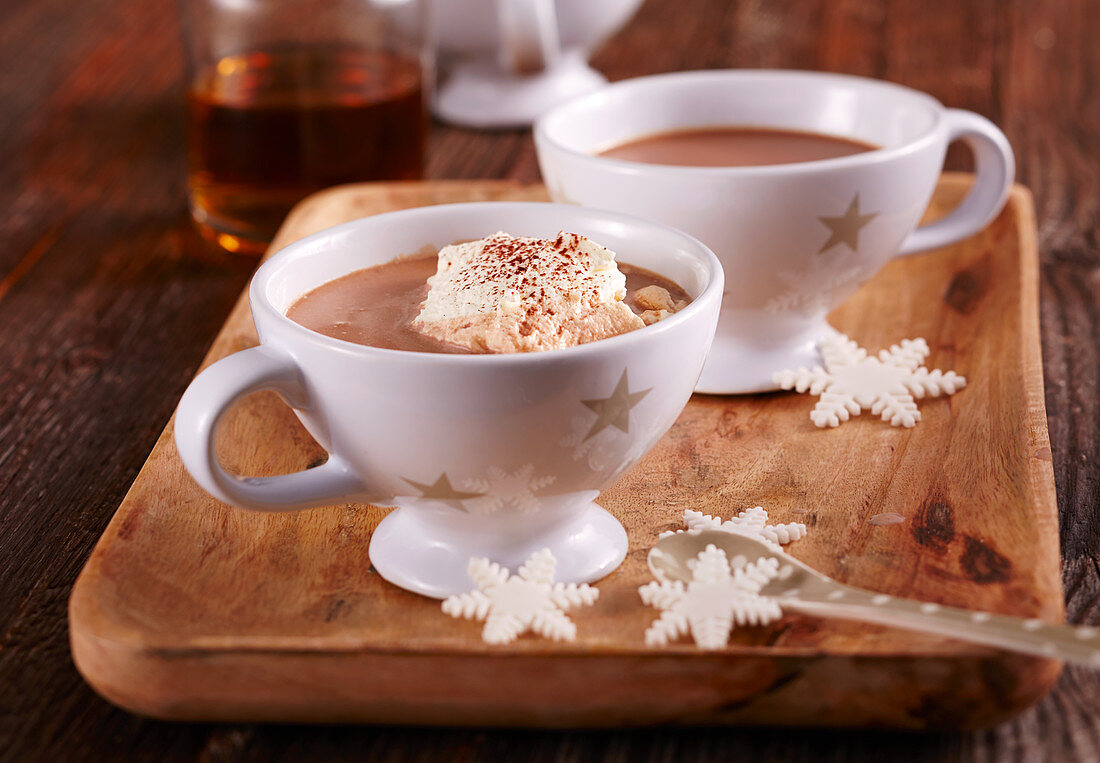 Hot chocolate with rum, vanilla sugar and cream in cups