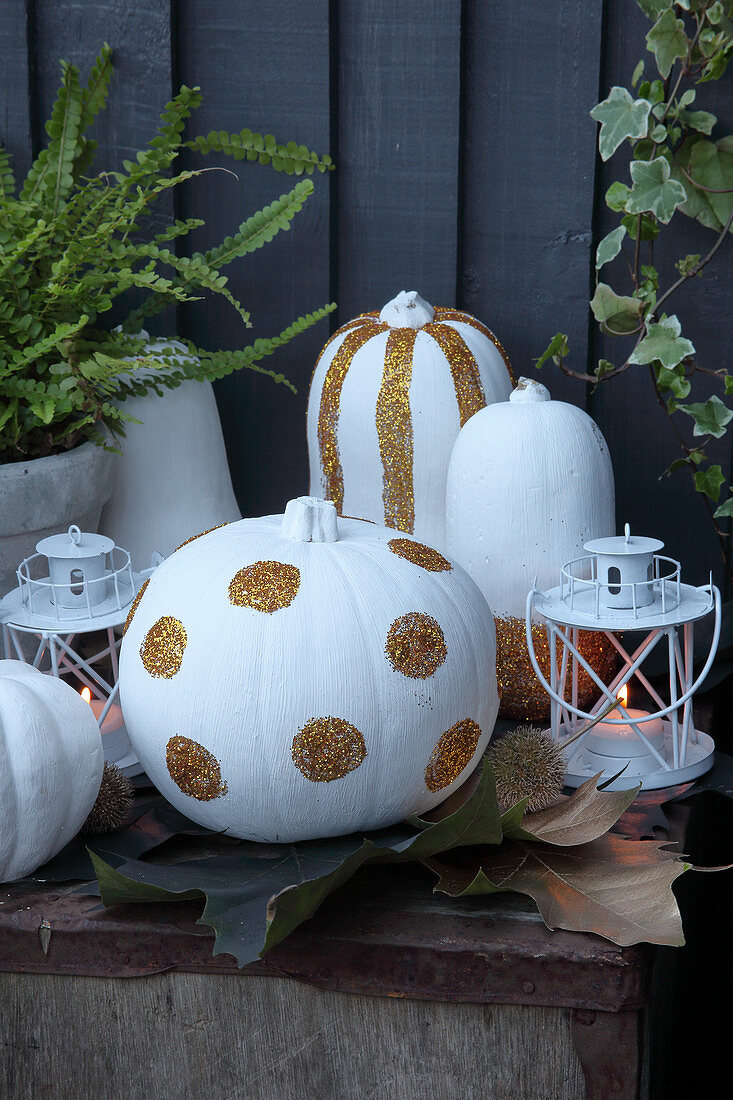 DIY Halloween decorations: white-painted pumpkins with glitter
