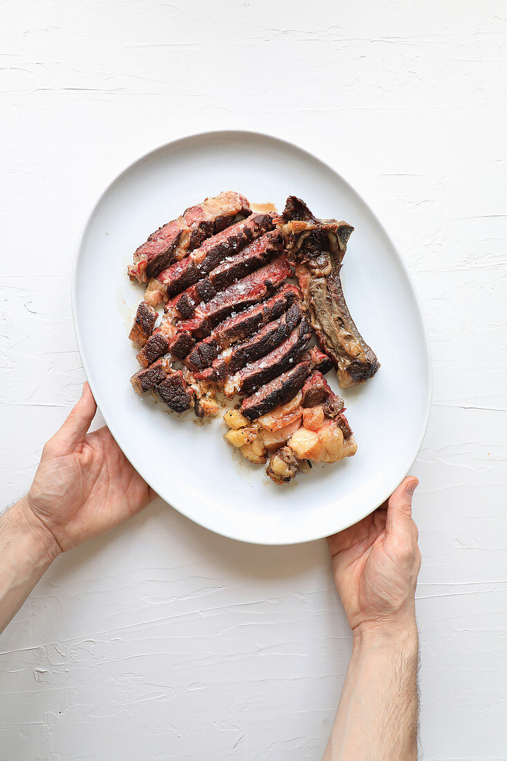 Rib-Steak mit Kartoffeln auf Servierplatte