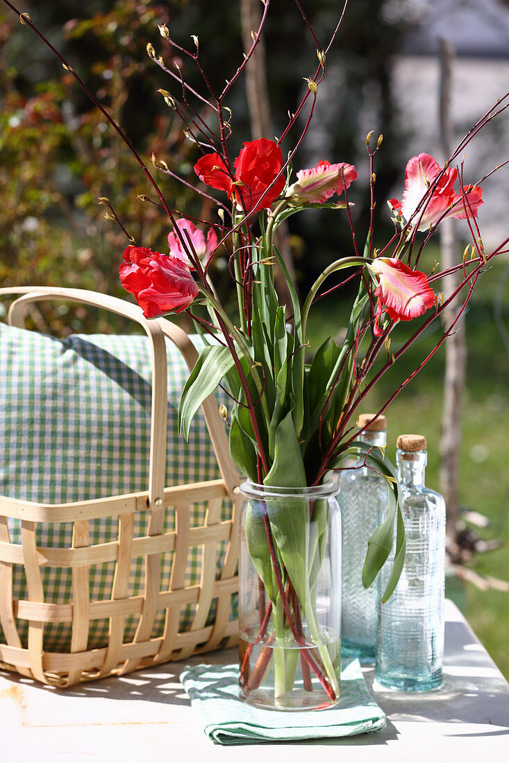 Bouquet of tulips and branches on garden table