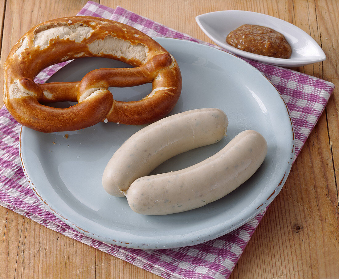 A pair of white sausages with pretzel and sweet mustard (snack, Bavaria)