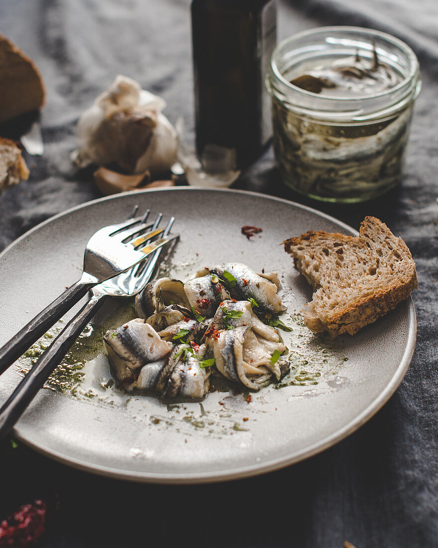 Marinated anchovies served in a plate with multi cereal bread