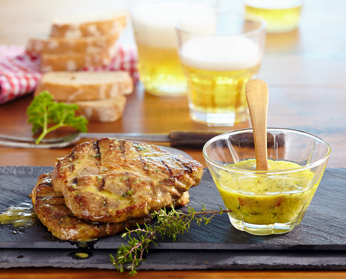 Grilled pork steaks in a herb and mustard marinade, beer and white bread