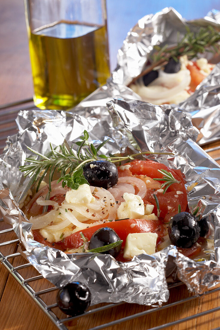 Grilled tomatoes, sheep's cheese, onions and olives in aluminium foul