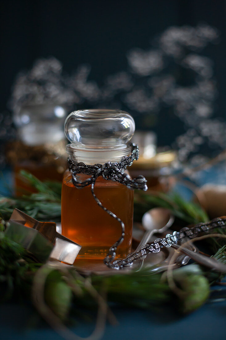 Vintage winter arrangement of two jars of honey decorated with old ribbons