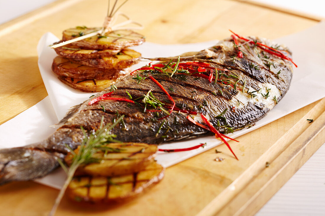 A whole, grilled bream with jalapenos, herbs and potatoes