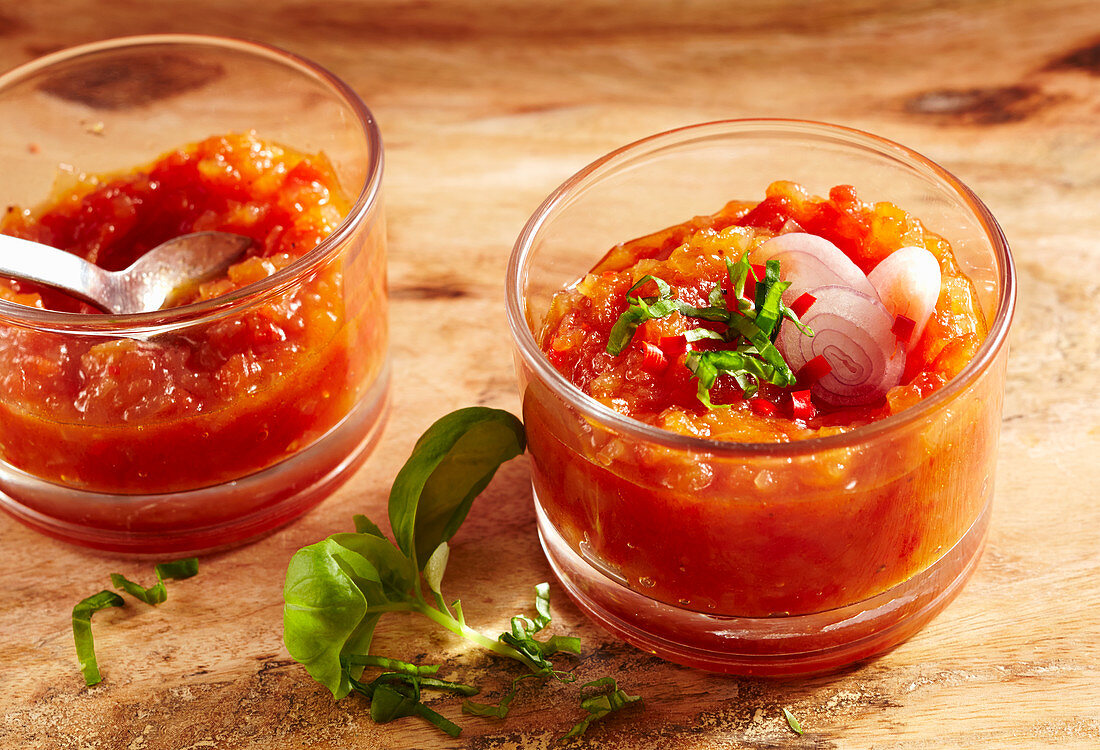 Spicy tomato chutney in jars with basil