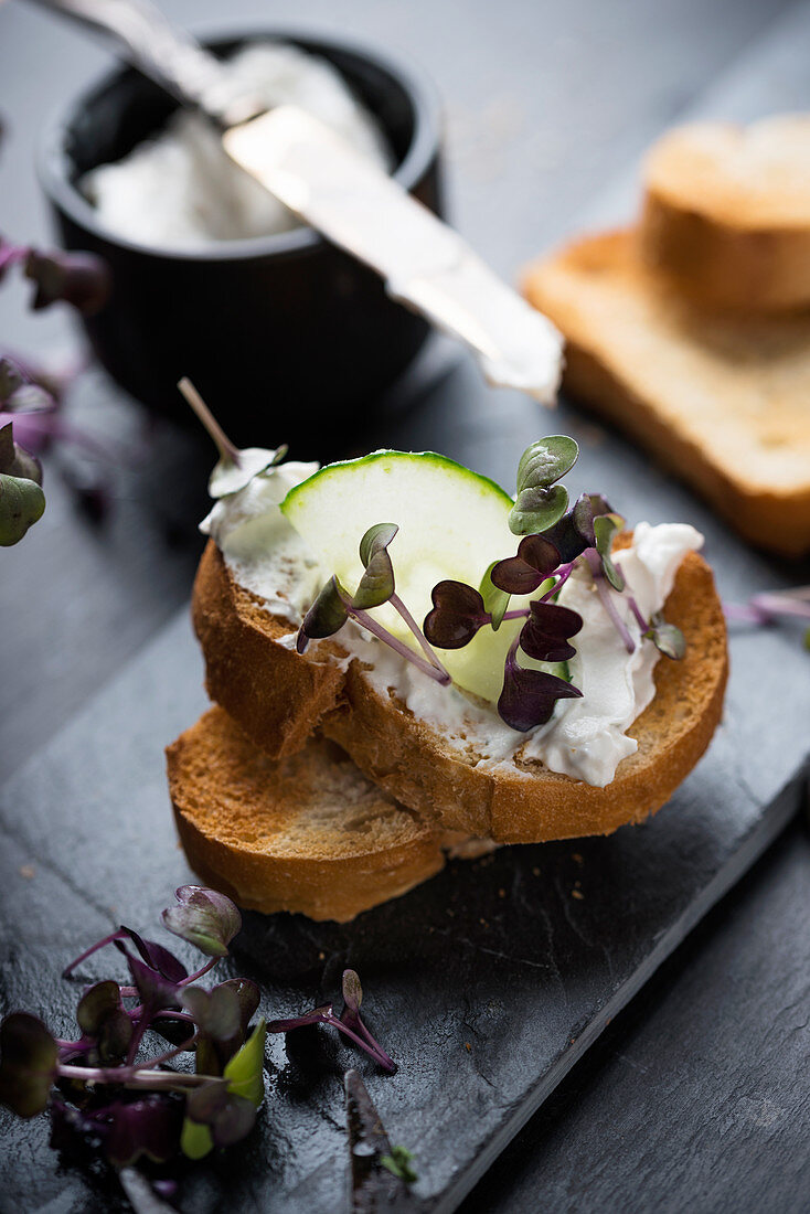 Geröstetes Baguette mit Cashewcreme, Gurke und Kresse