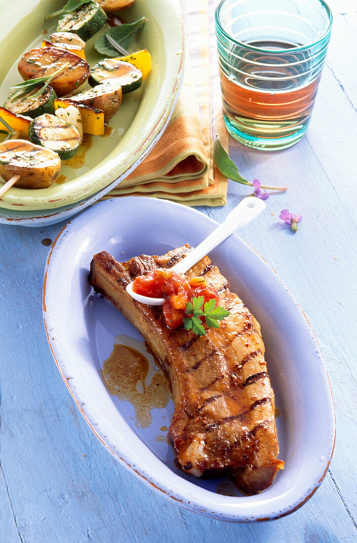 Grilled spare ribs with vegetable skewers and a tomato dip