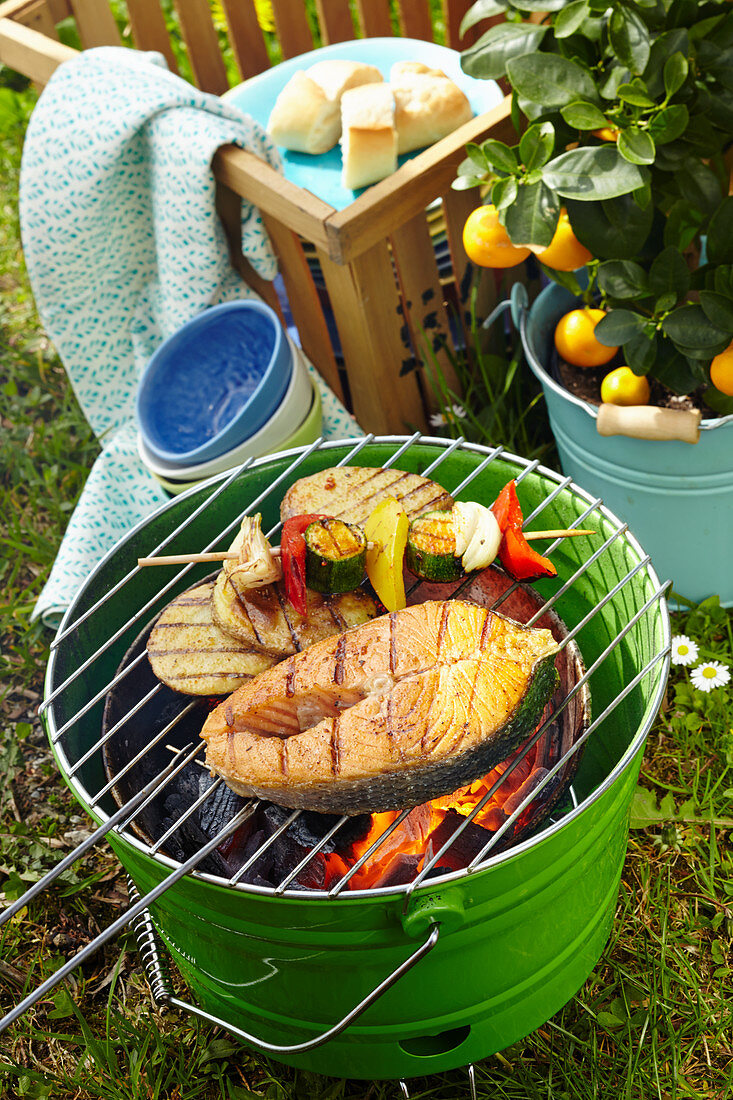 Marinated Cajun salmon, vegetables skewers and spicy potatoes on a barbecue