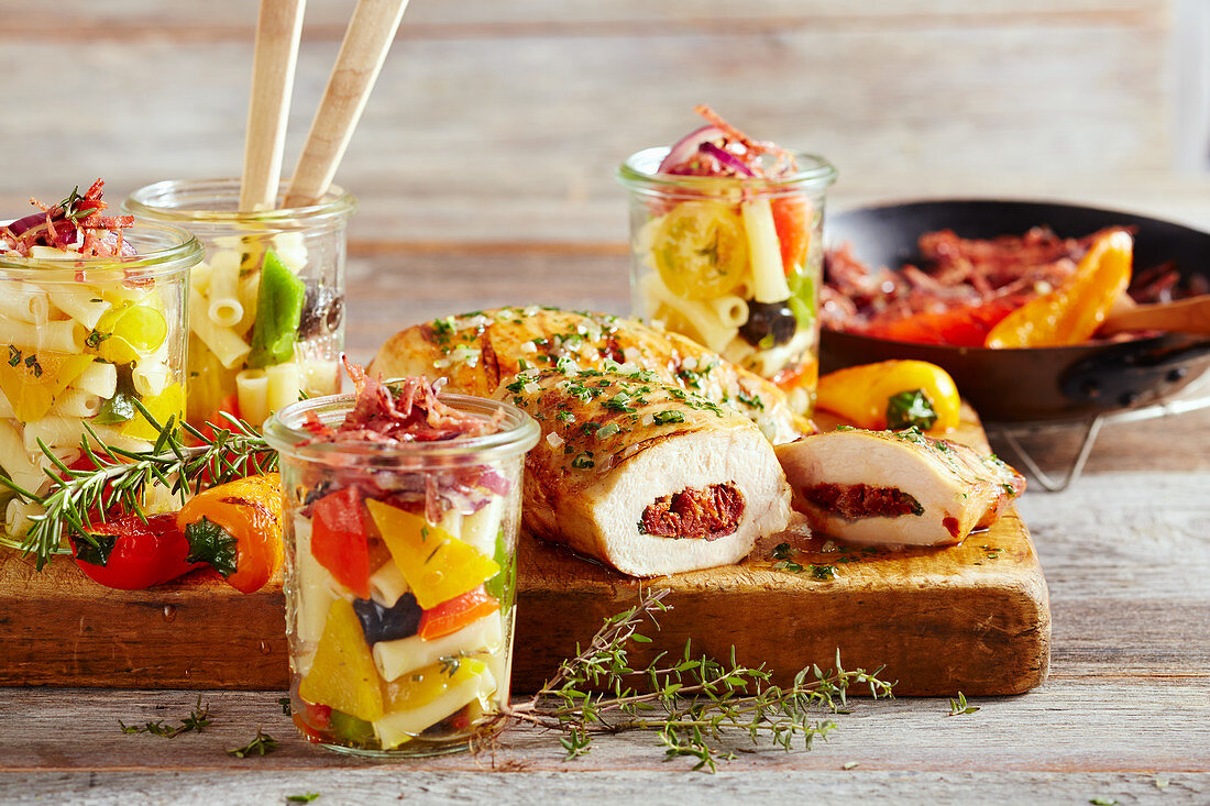 Gegrillte Hähnchenbrust mit mediterraner Füllung und Nudelsalat in Gläsern