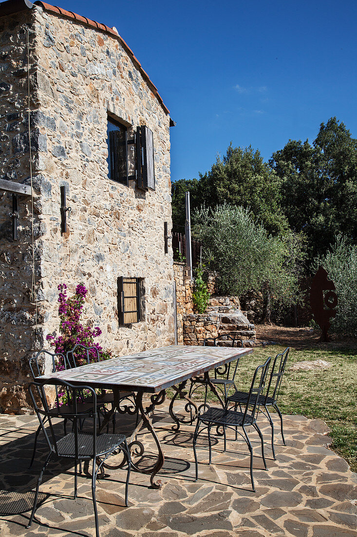 Tisch und Stühle auf der Terrasse eines italienischen Steinhauses