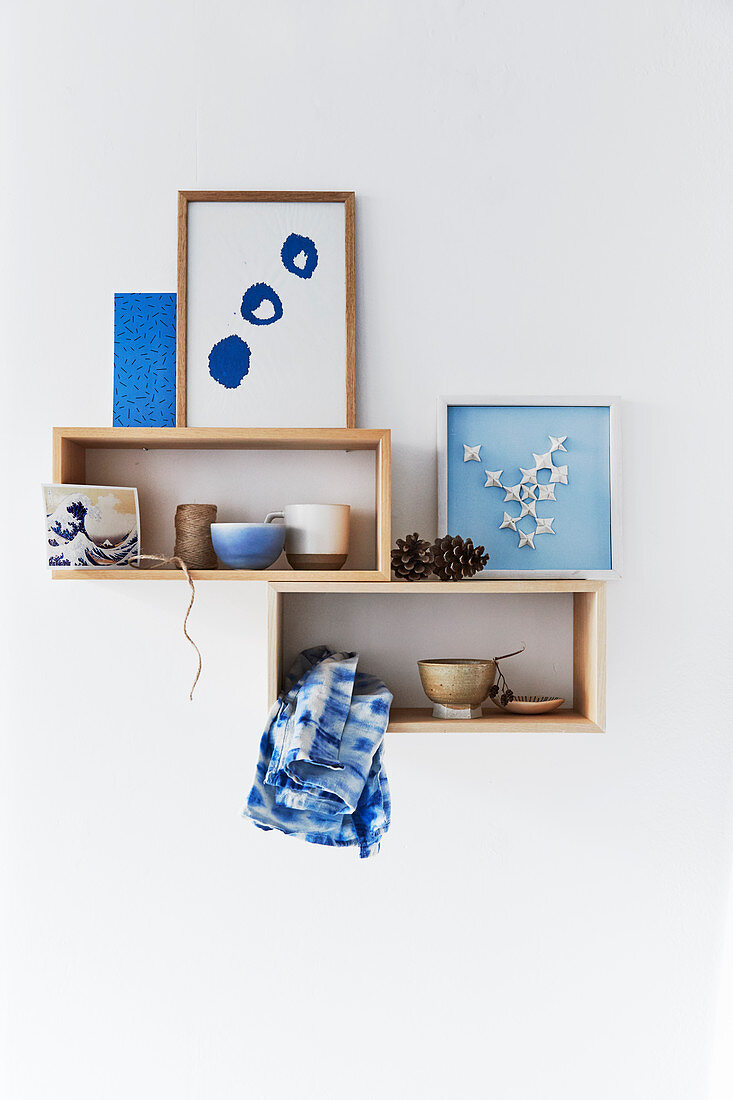 Holzregal mit Schalen und DIY-Bildern in Blau und Weiß