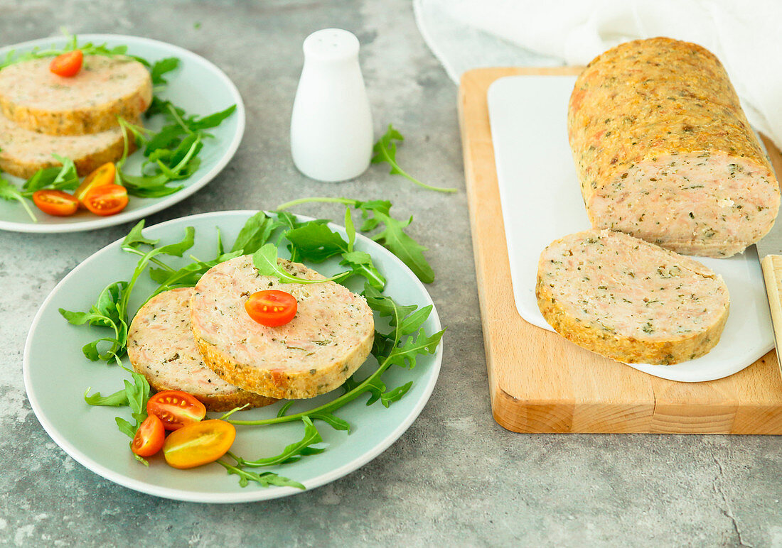 Baked turkey meatloaf with mortadella and aromatic herbs served with rocket and tomatoes