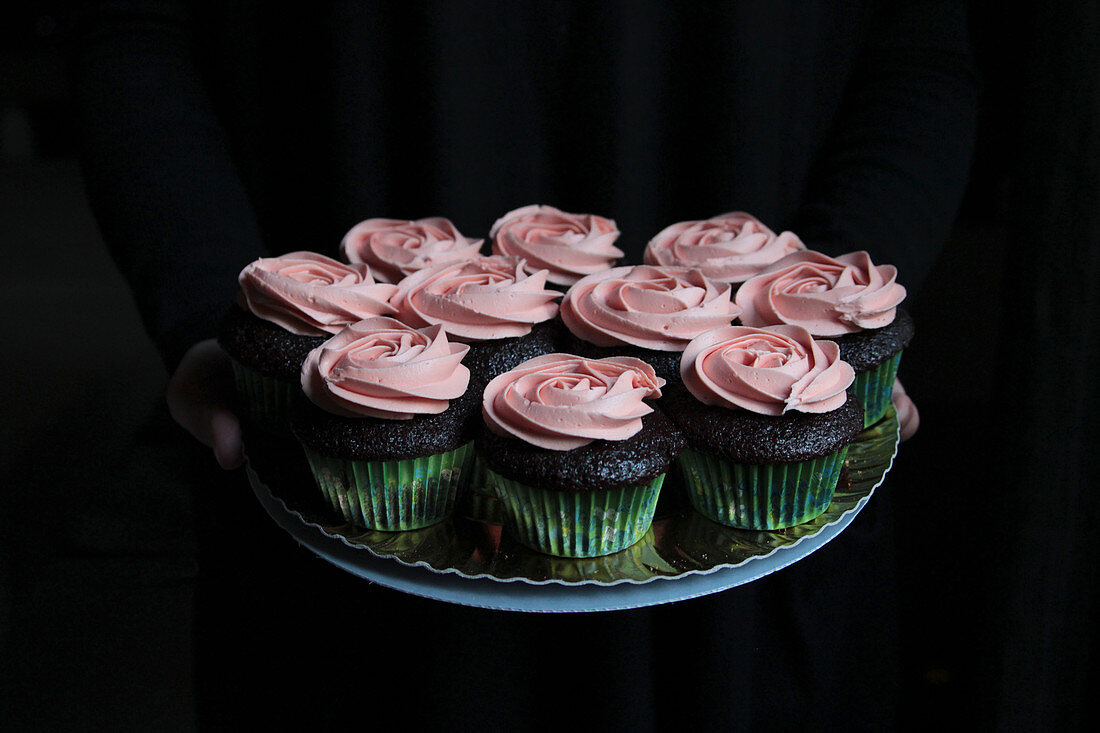 Tasty sweet cupcakes decorated with pink cream