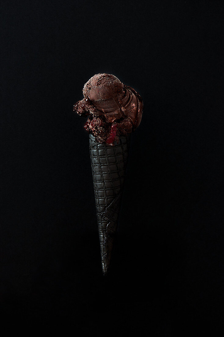 Schwarze Eistüte mit dunklem Schokoladen-Himbeer-Eis