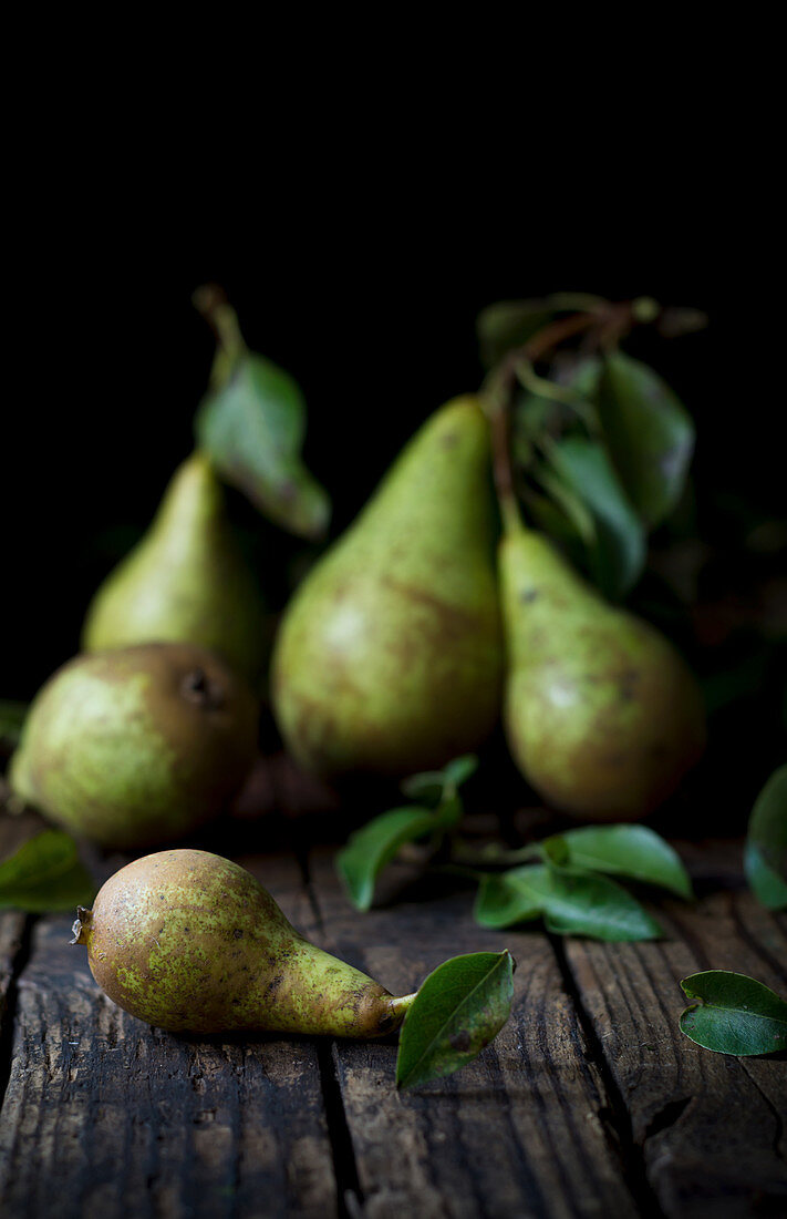 Pears with leaves on a dark wooden surface