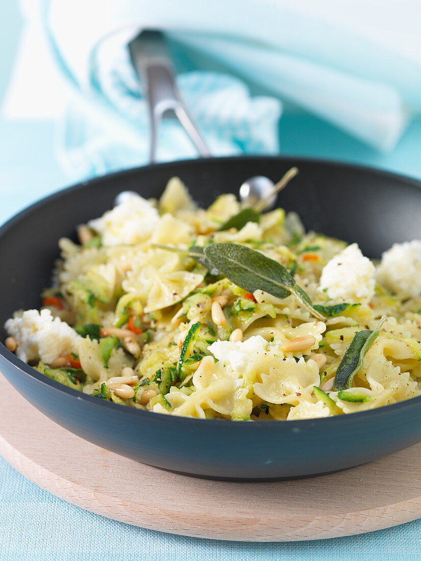 Farfalle in a pan with courgette, pine nuts, sage and mozzarella