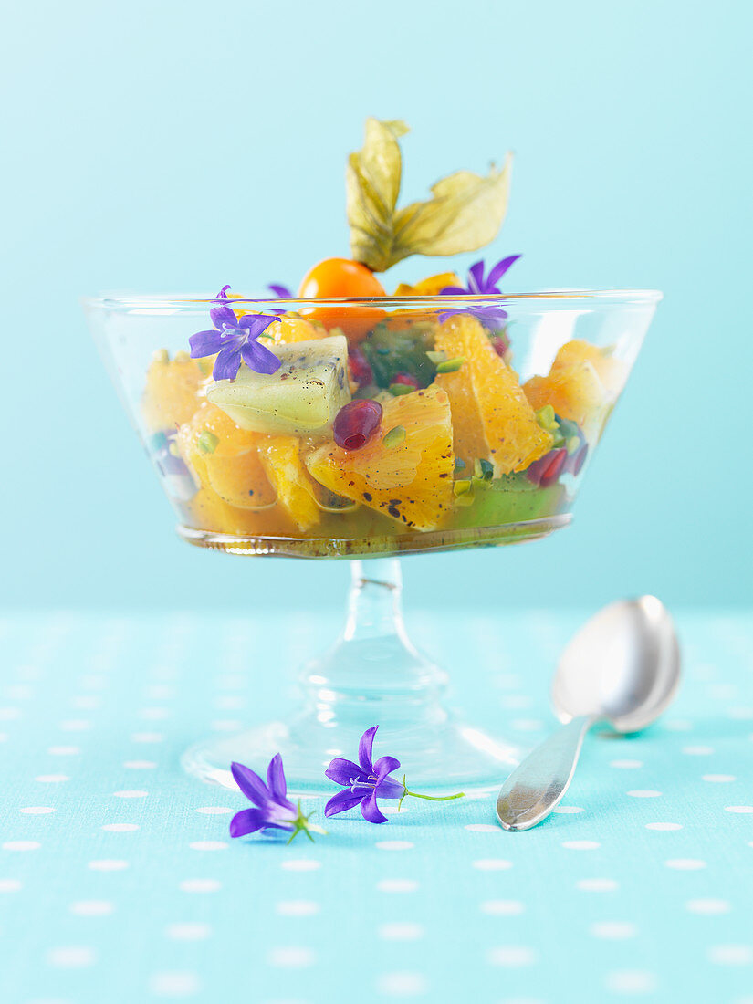 Orange salad with kiwi and purple edible flowers