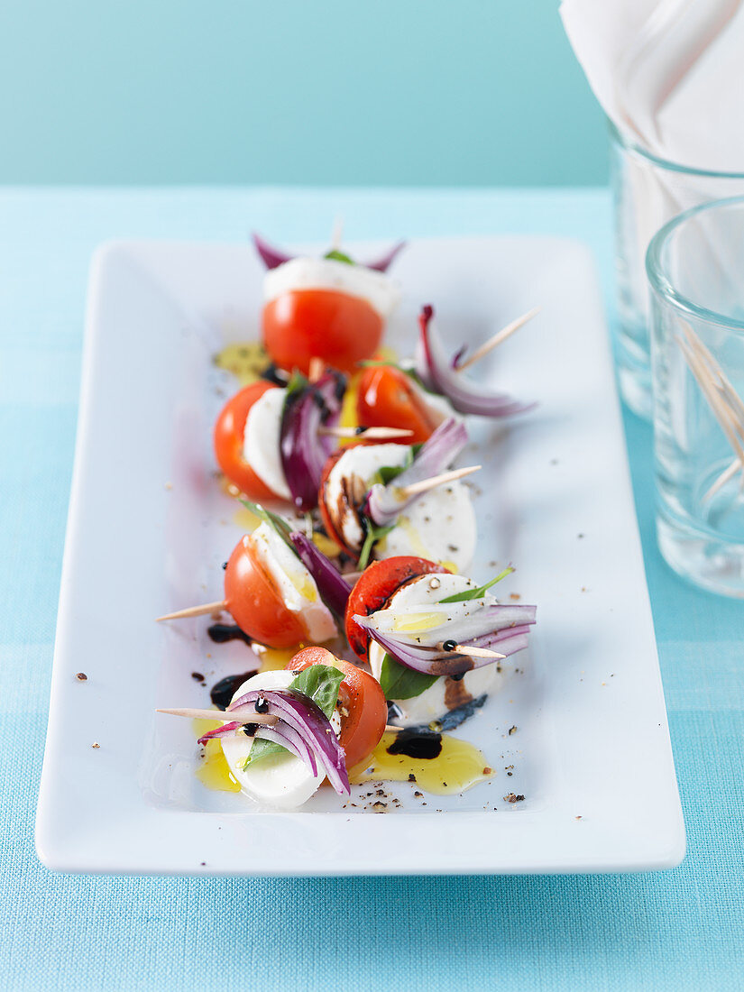 Tomato and mozzarella skewers with red onions and basil