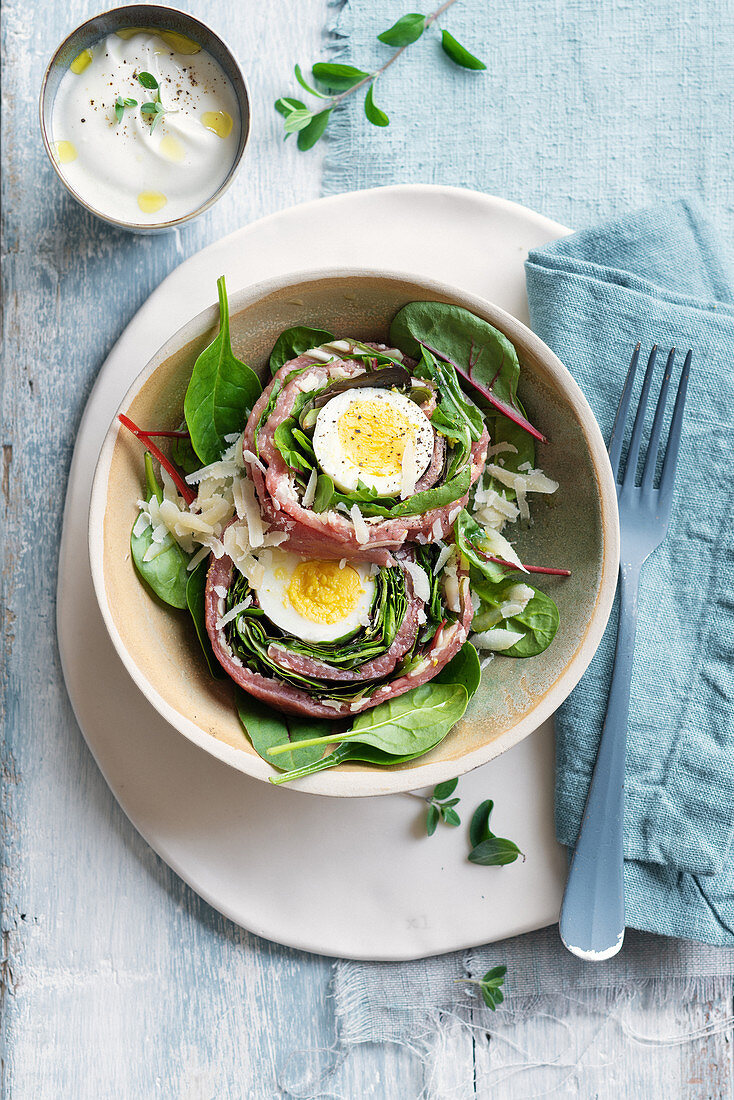 Carpaccio-Rouladen mit gekochtem Ei, Pflücksalat und Joghurt-Meerrettich-Sauce